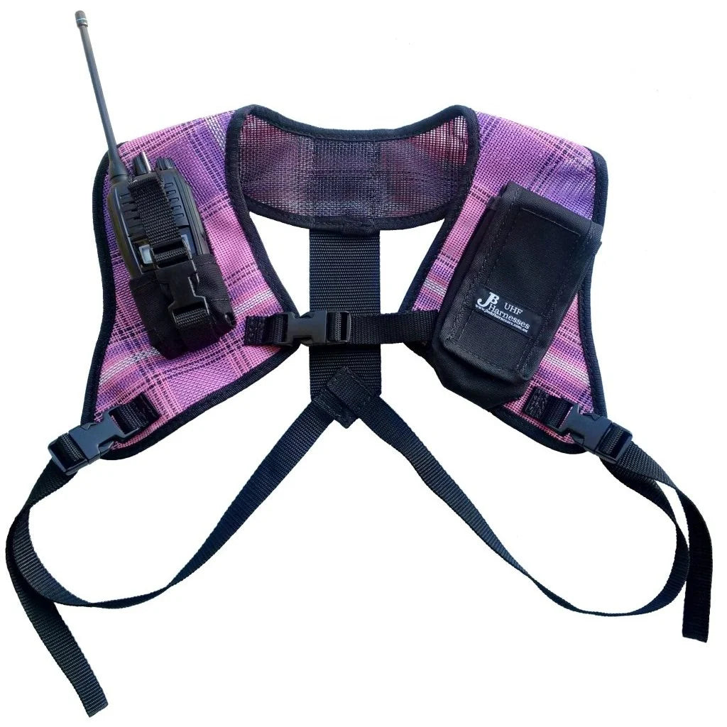 A purple and pink plaid tactical dog harness with black straps, a radio attachment on the left, and a pouch on the right, shown against a plain white background.