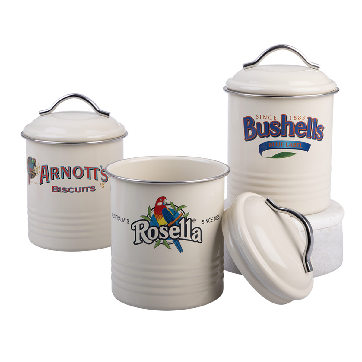 Three vintage cream enamel canisters with metal handles and lids, featuring printed brand logos including Arnott's Biscuits, Rosella, and Bushells, arranged on a white background.