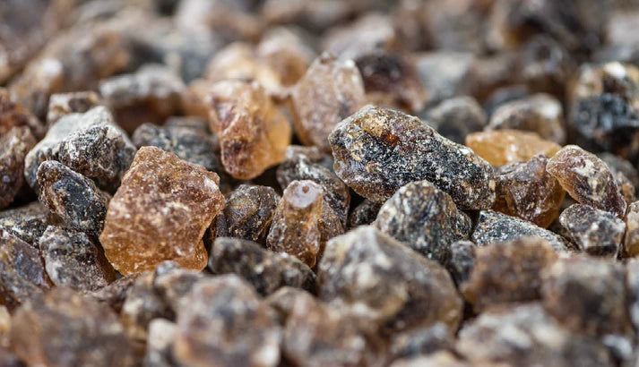 Roughstock Bull Rosin Rocks -400g Bag Black. Close-up of amber-colored resin or frankincense stones.