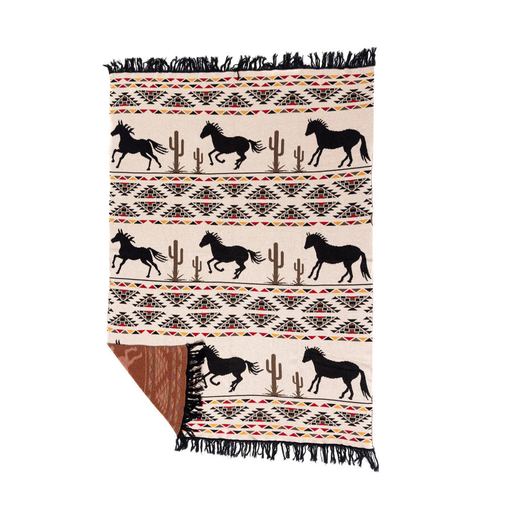Chisholm Trail Throw. A western-themed throw blanket with geometric patterns and saguaro cactus, featuring black horses on a beige background with fringes.