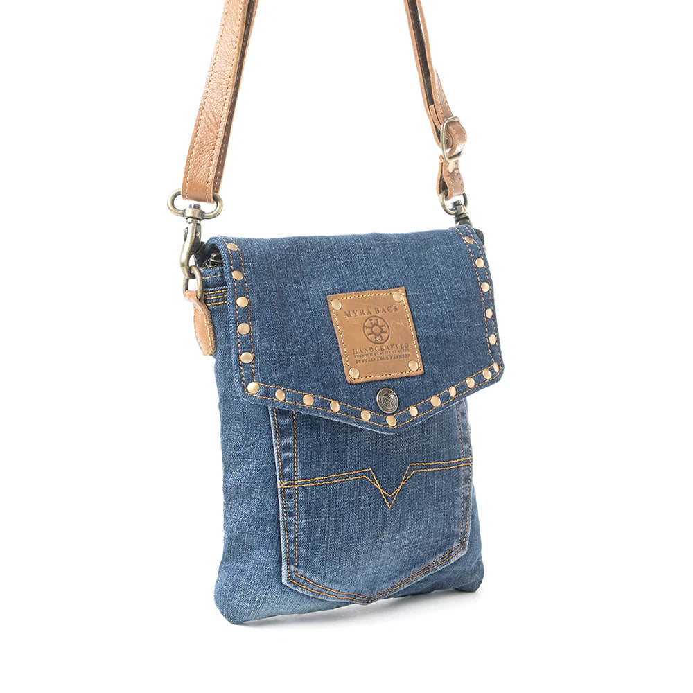 Denim crossbody bag with studded details on a white background