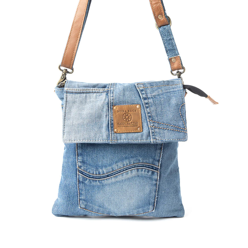 Denim crossbody bag with leather straps on a white background