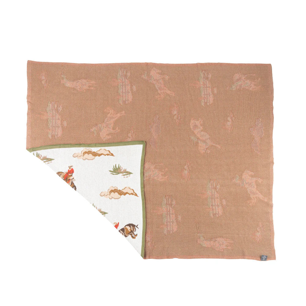 Folded blanket with nature-themed design on a white background