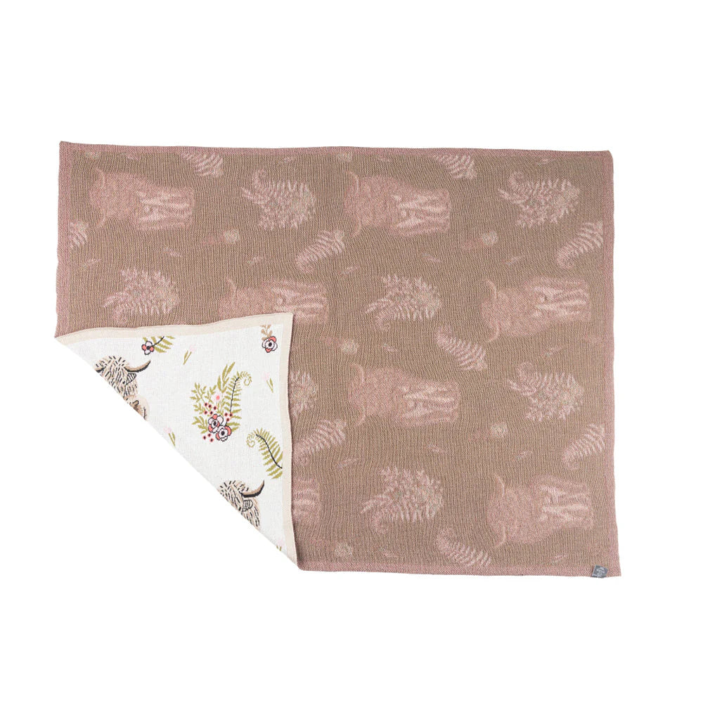 Fabric with animal pattern on one side and embroidered corner on the other, on a white background