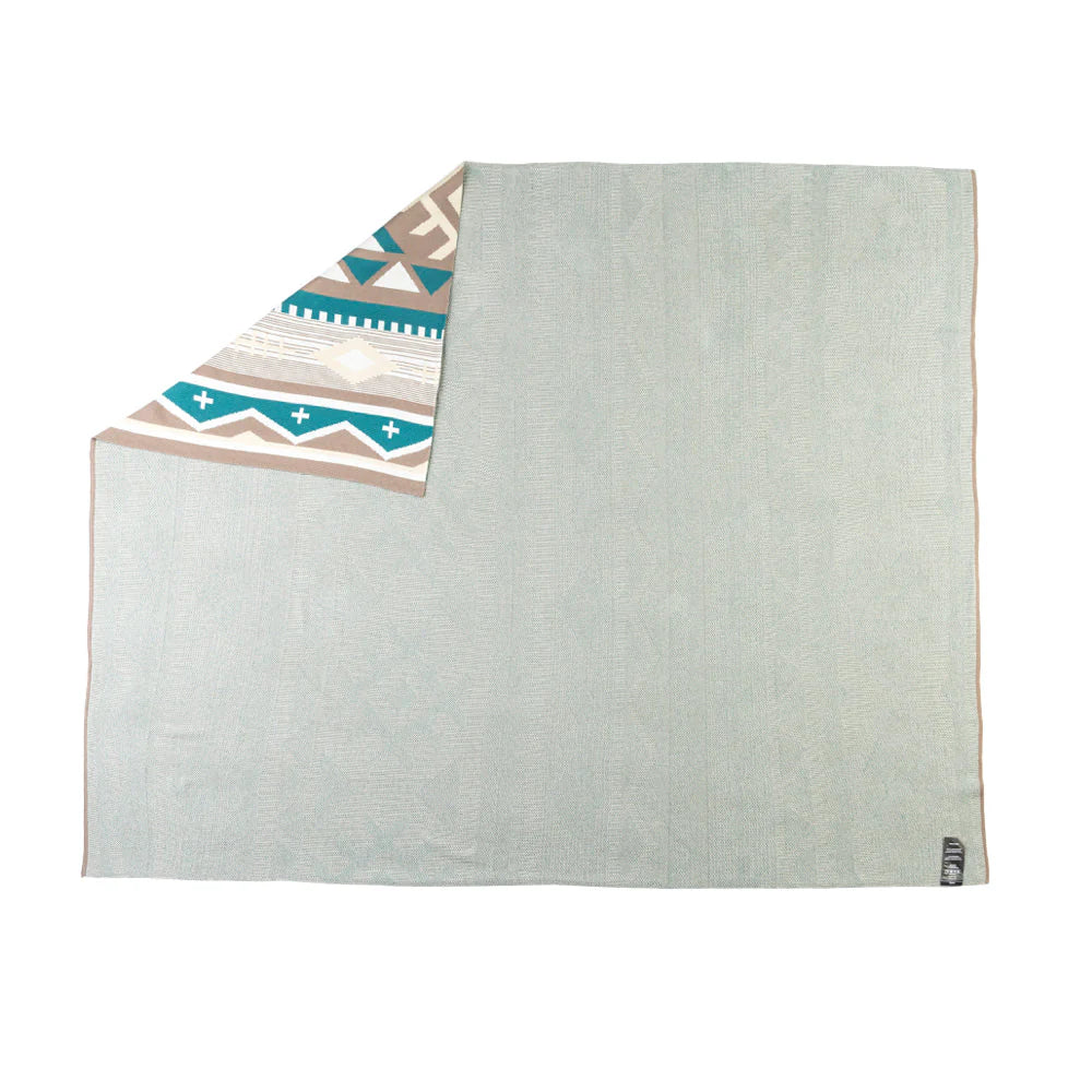 Two towels, one with a geometric pattern and the other plain, on a white background