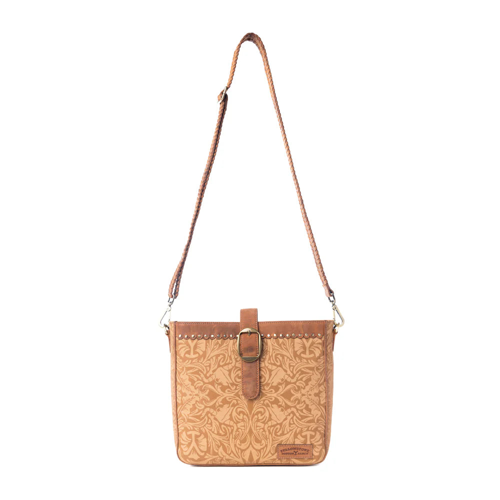 Yellowstone Montana Amber Buckle Sling Bag. Brown leather crossbody bag with floral pattern on a white background