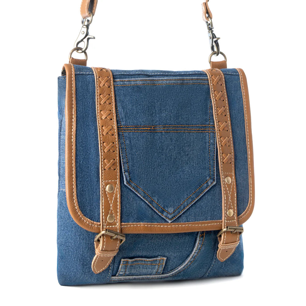 Blue denim bag with brown leather straps on a white background