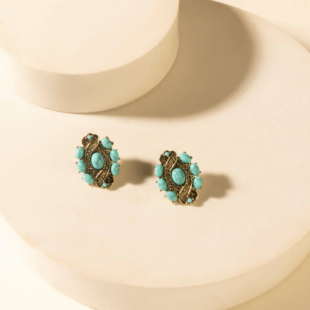 Pair of turquoise earrings on a beige background