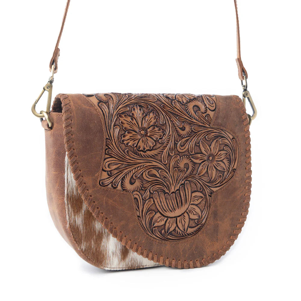 Brown leather handbag with floral patterns on a white background
