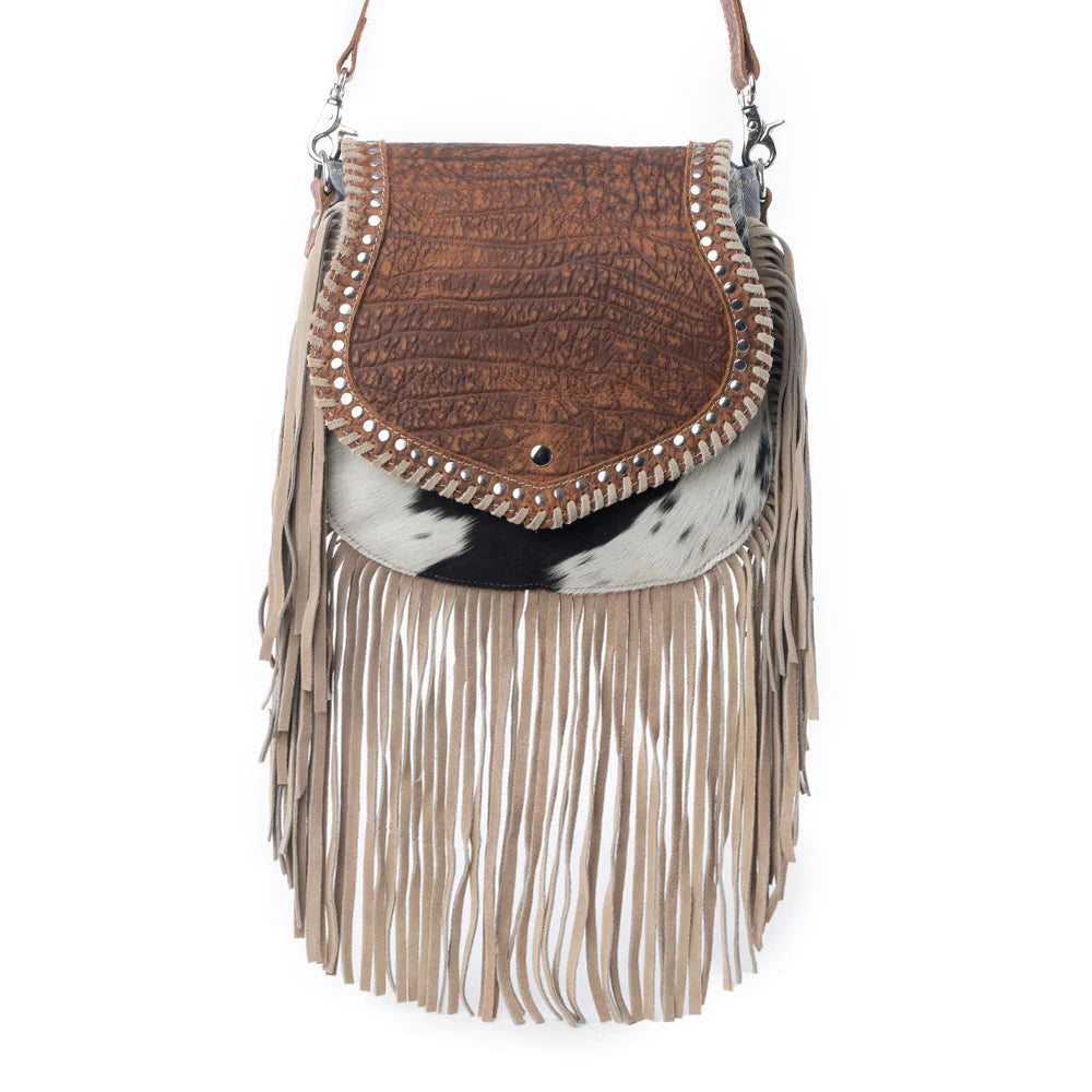 Brown leather handbag with cowhide pattern and fringes on a white background