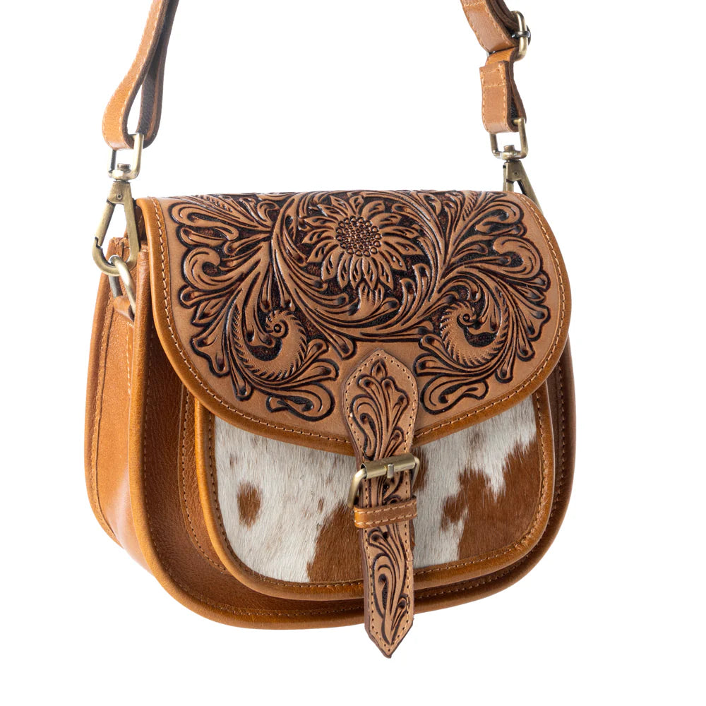 Brown leather handbag with intricate patterns and a cowhide flap on a white background