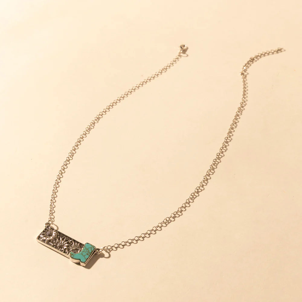 Necklace with a green gemstone on a beige background