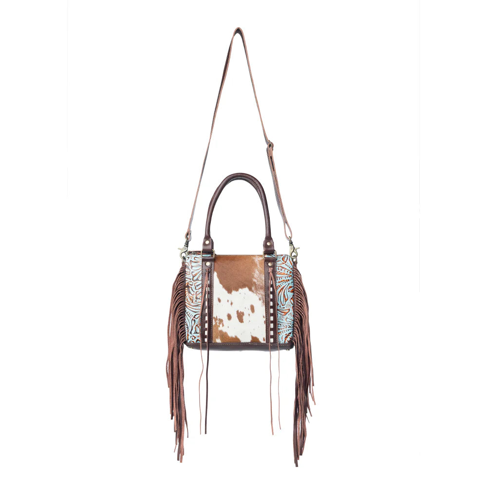 Brown leather handbag with fringe and patterned interior on a white background