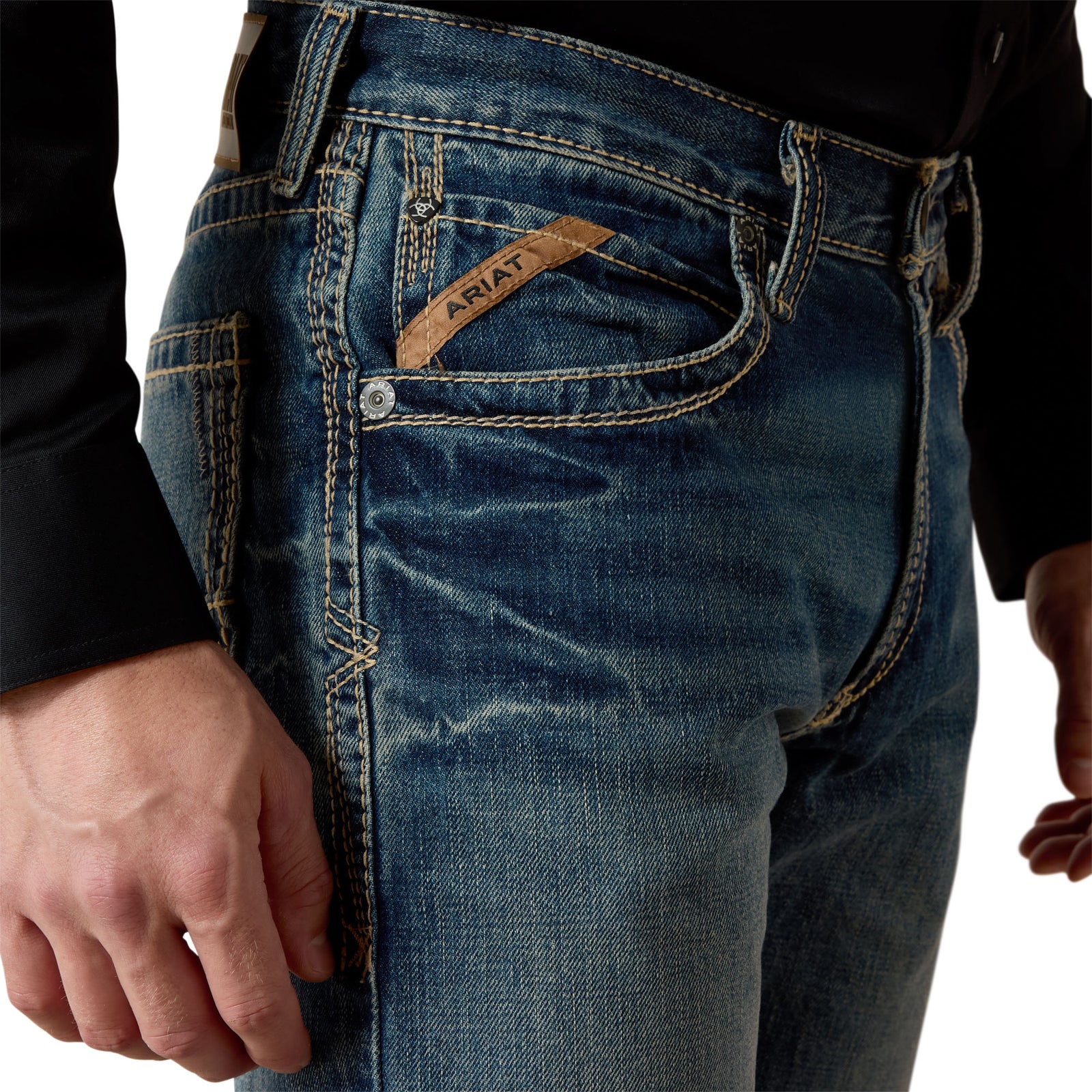 Ariat Men's M5 Boundary Straight Leg Jean. Close-up of blue jeans with Ariat branding on a white background