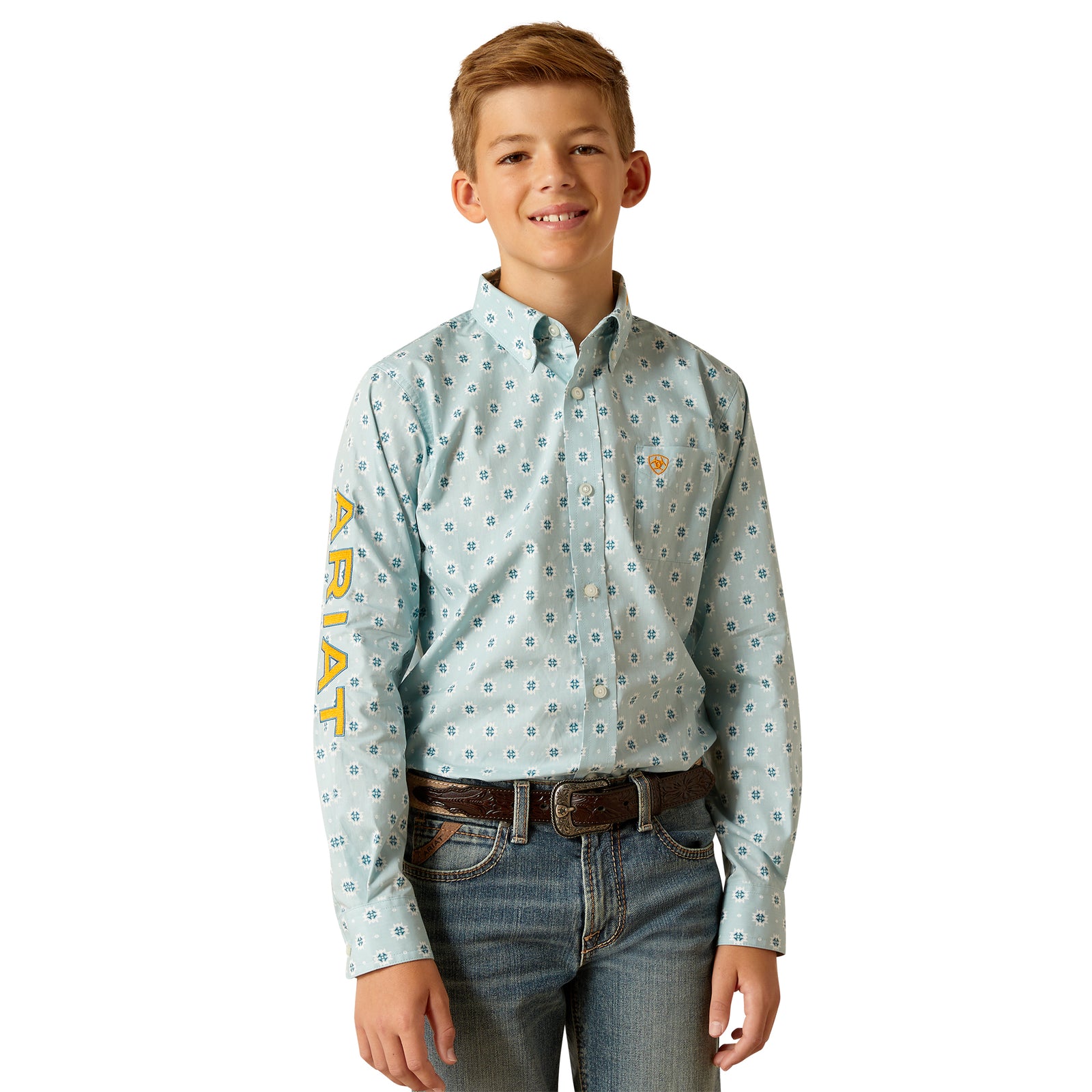 Ariat Boy's Team Colton Classic Fit L/S Shirt. A boy wearing a long-sleeved, geometric patterned, button-up shirt in light blue color, with the brand name 'Ariat' on the sleeve.