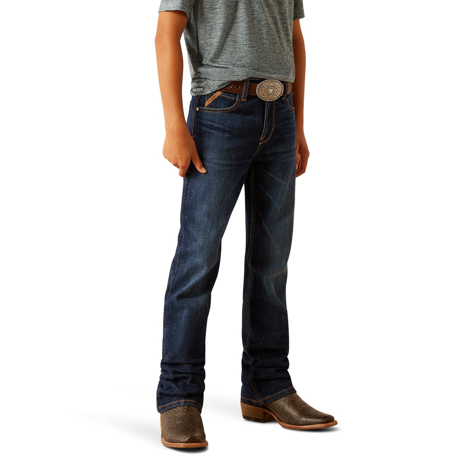 Ariat Boy's B4 Rolland Relaxed Fit Jean. A boy wearing a pair of Ariat brand blue jeans and brown boots.