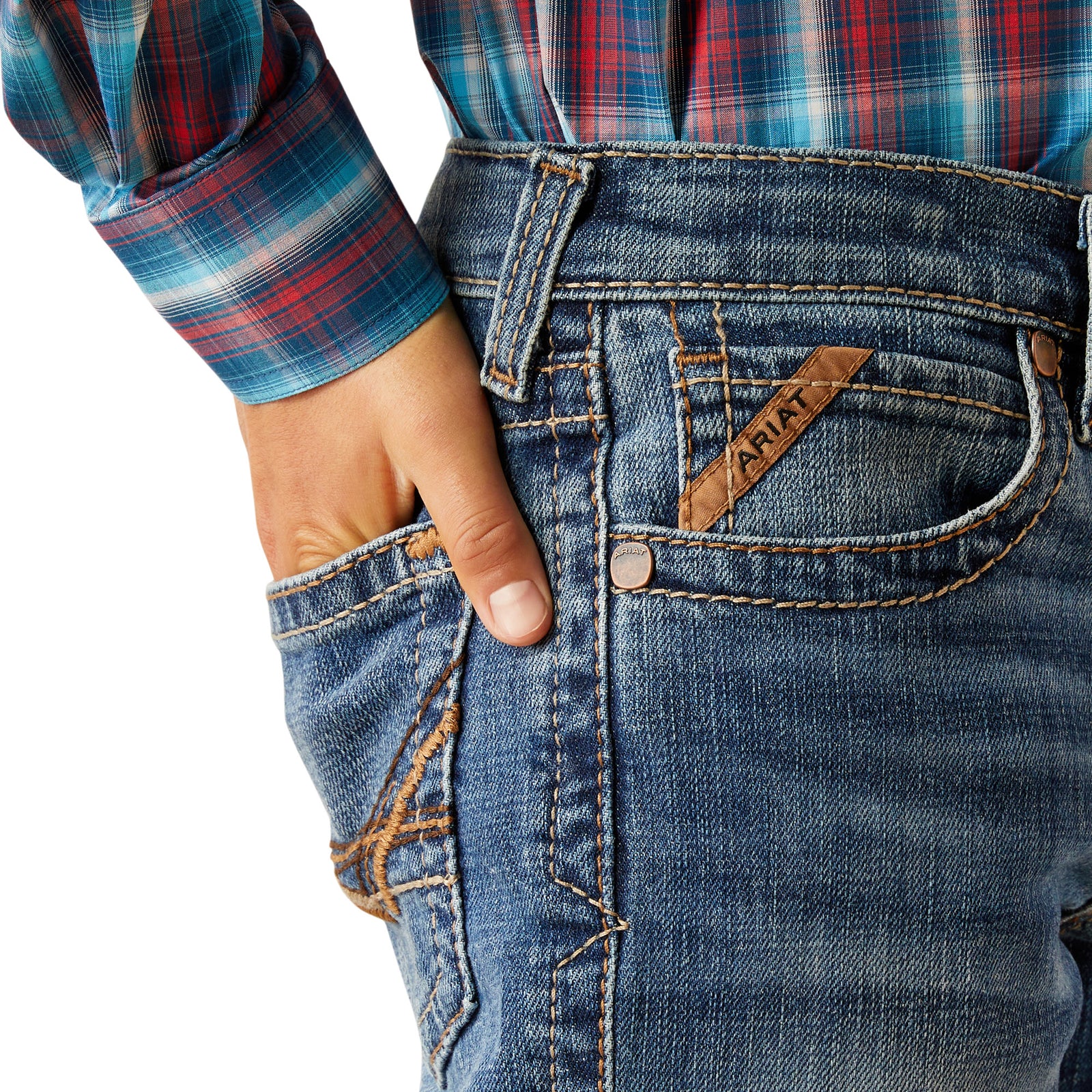 Ariat Boy's B5 Slim Bennet Straight Leg Jean. Close-up of blue jeans with a brand label, worn with a plaid shirt.