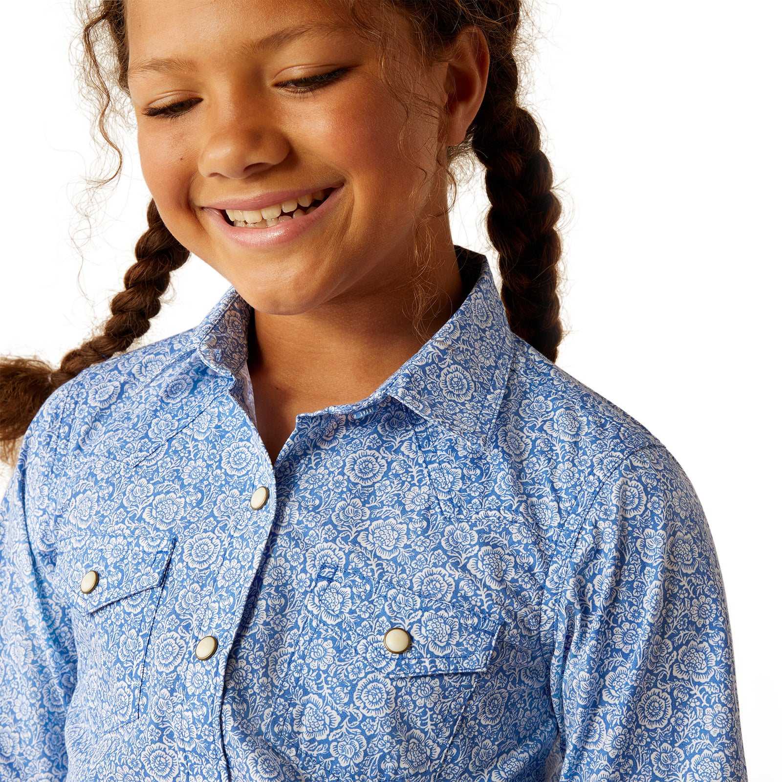 Ariat Girl's Shannon L/S Snap Western Shirt. Young girl wearing a blue patterned shirt with braided hair on a white background