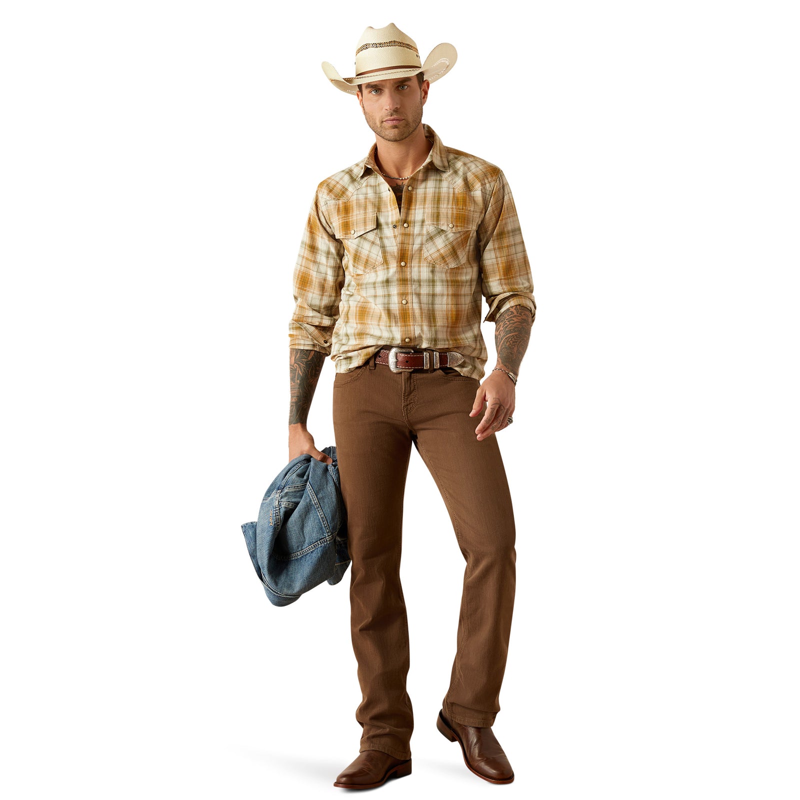 Ariat Men's Halston Retro Fit L/S Western Shirt. Man wearing a plaid shirt, brown pants, and a cowboy hat holding a blue jacket on a white background