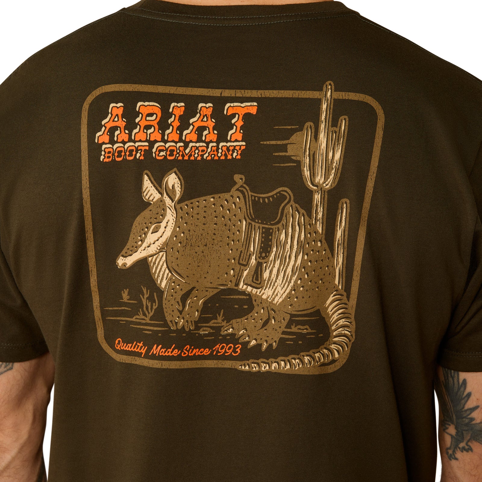 Ariat Men's Armadillo on a Half Shell T-Shirt. Brown t-shirt with armadillo and cactus graphic on the back.