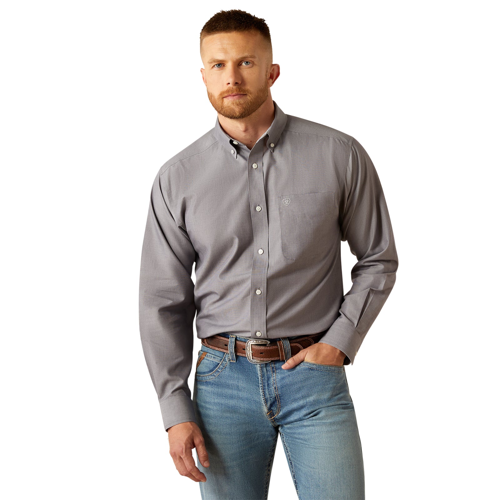 Ariat Men's Wrinkle Free Solid L/S Western Shirt. Man wearing a gray button-up shirt and blue jeans on a white background