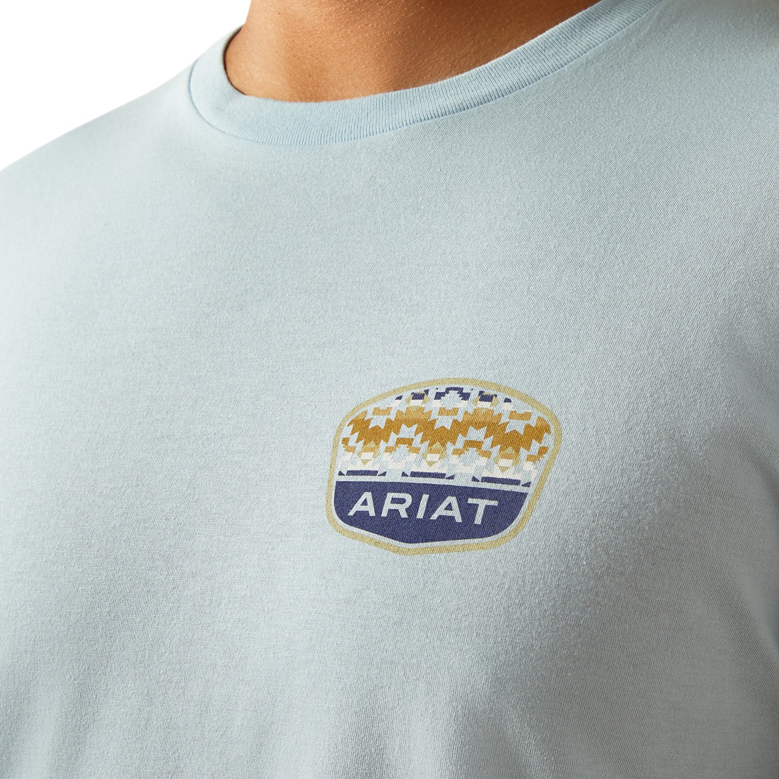 Ariat Men's Ogden Valley Badge T-Shirt. Light blue t-shirt with Ariat logo on a white background
