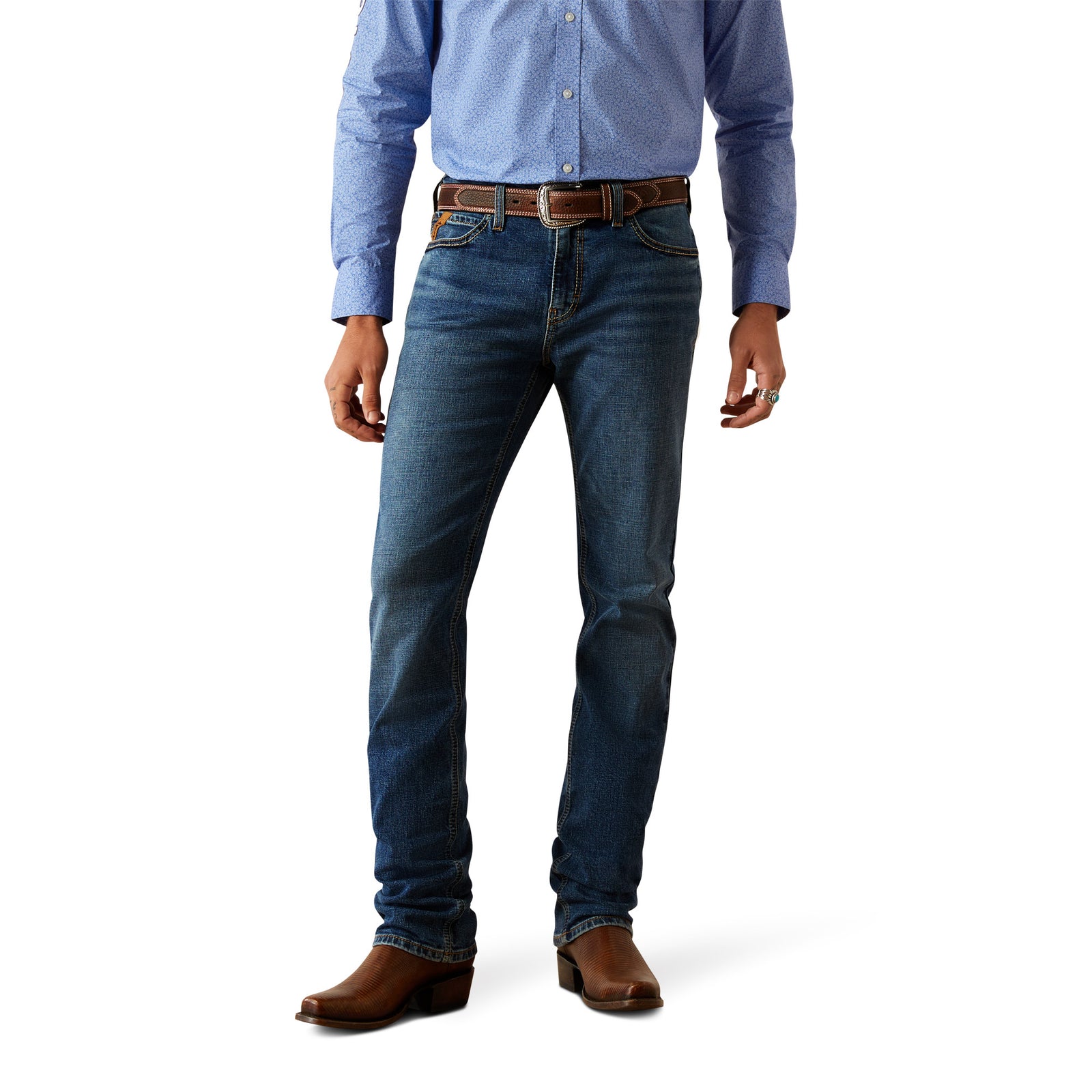 Ariat Men's M8 Miles Modern Fit Jean. A man wearing a blue shirt, blue jeans, and brown boots.