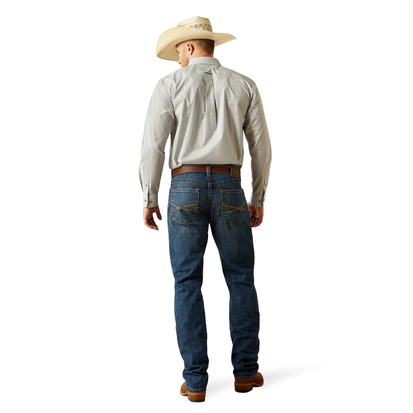Ariat Men's M4 Norwich Relaxed Fit Jean. Man wearing a light-colored shirt, blue jeans, and a cowboy hat on a white background