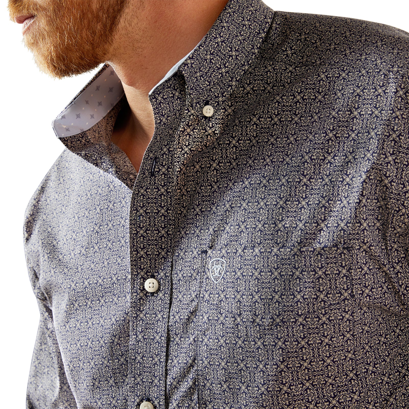 Ariat Men's Wrinkle Free Douglas L/S Western Shirt. Close-up of a patterned shirt with a brand logo on a white background