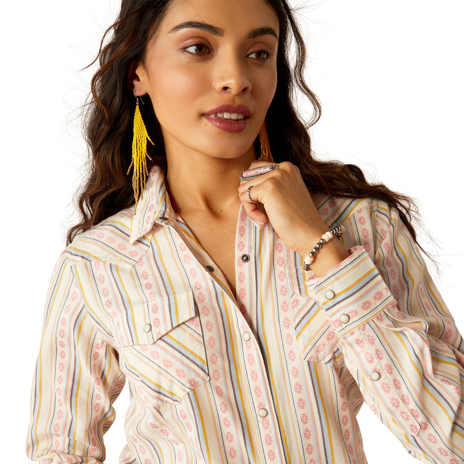 Ariat Women's Alyssa Snap L/S Western Shirt. Woman wearing a patterned shirt with colorful earrings on a white background