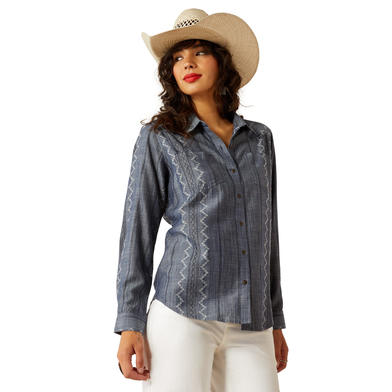 Ariat Women's Billie Jean L/S Western Shirt. Woman wearing a blue patterned shirt and white pants with a straw hat on a white background