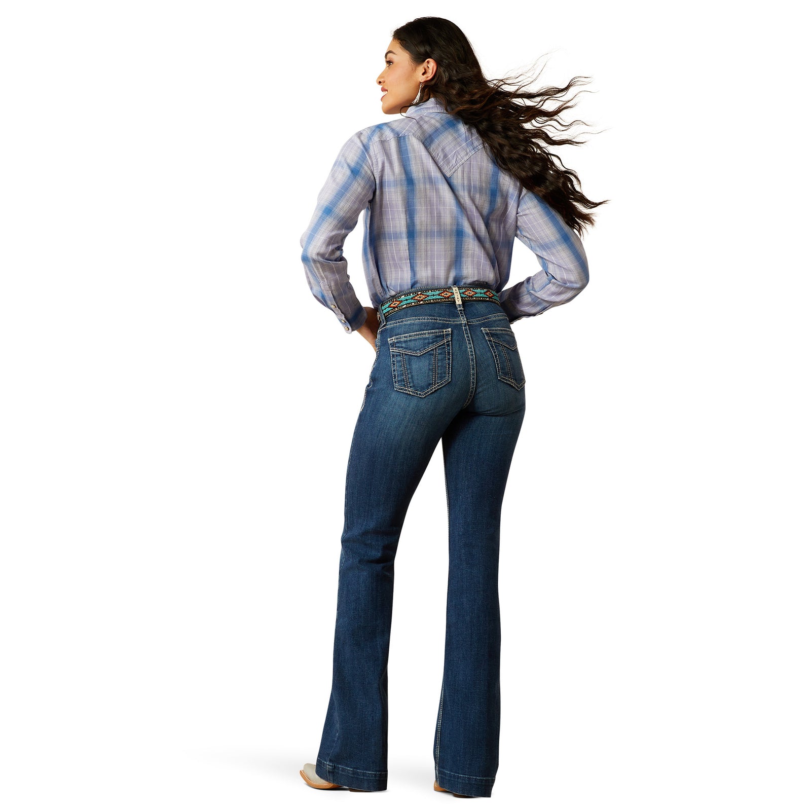 Ariat Women's Paula High Rise Slim Trouser. Woman wearing blue jeans and a plaid shirt on a white background