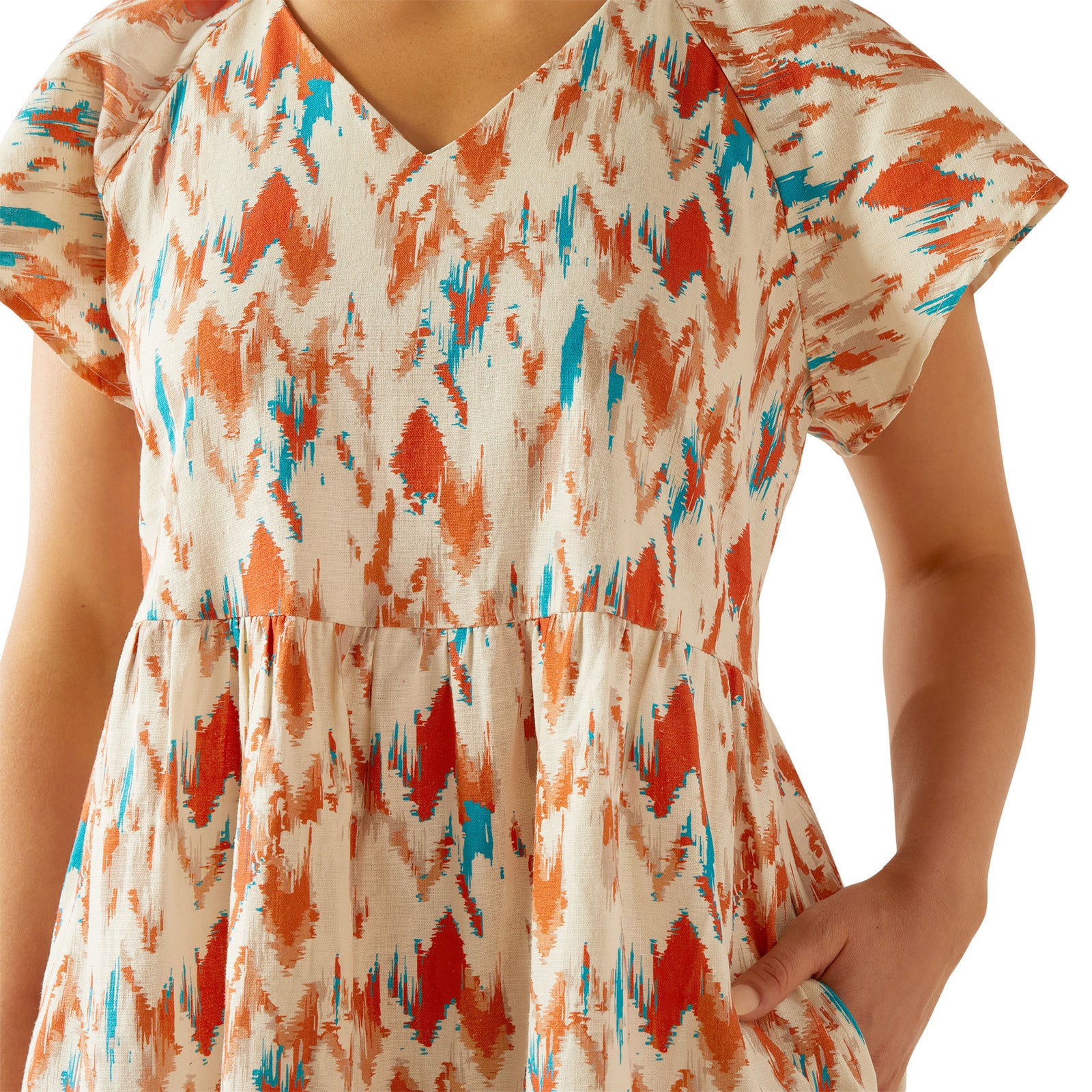 Ariat Women's Delilah Dress. Woman wearing a colorful dress with orange, blue, and red patterns on a white background