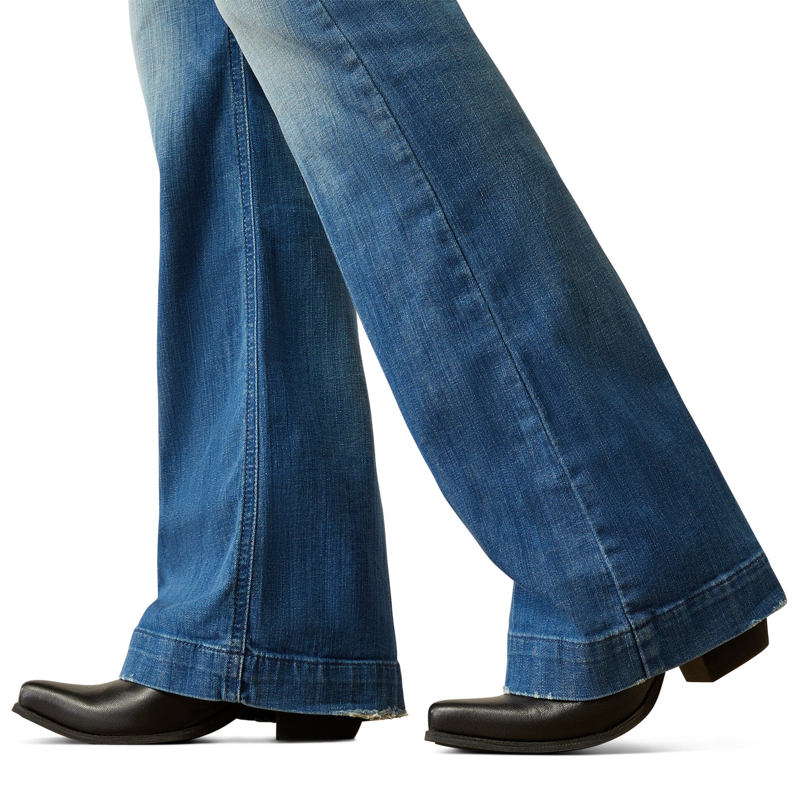 Ariat Women's Elaina High Rise Slim Trouser Jean. Close-up of blue jeans and black shoes on a white background