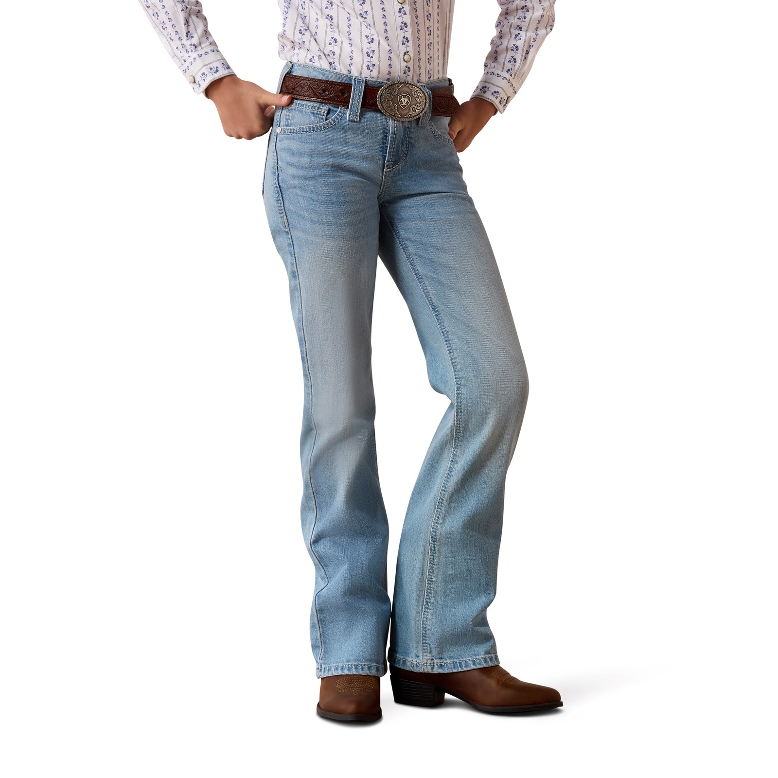 Person wearing light blue jeans and brown boots on a white background