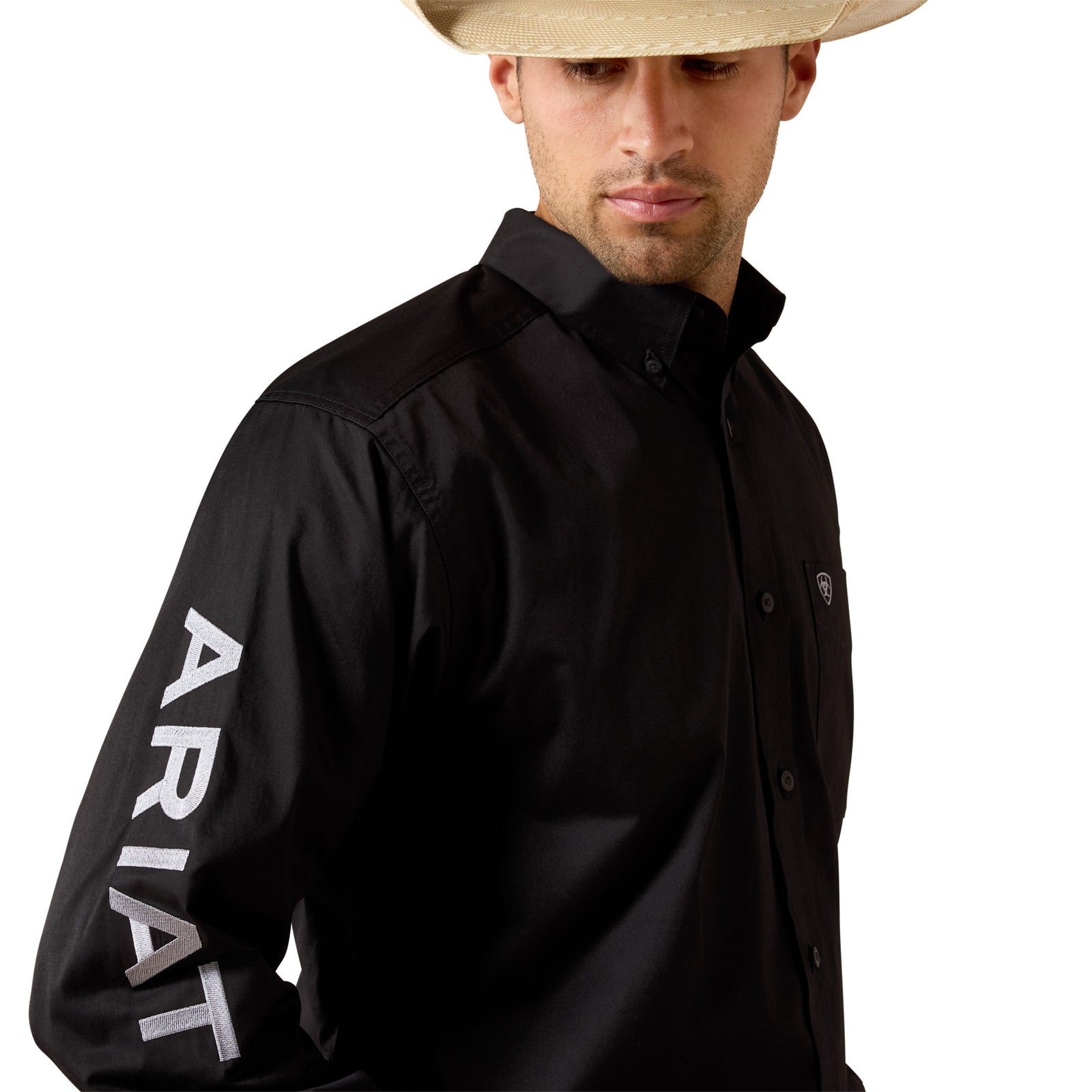 Man wearing a black shirt with 'Ariat' branding on a white background