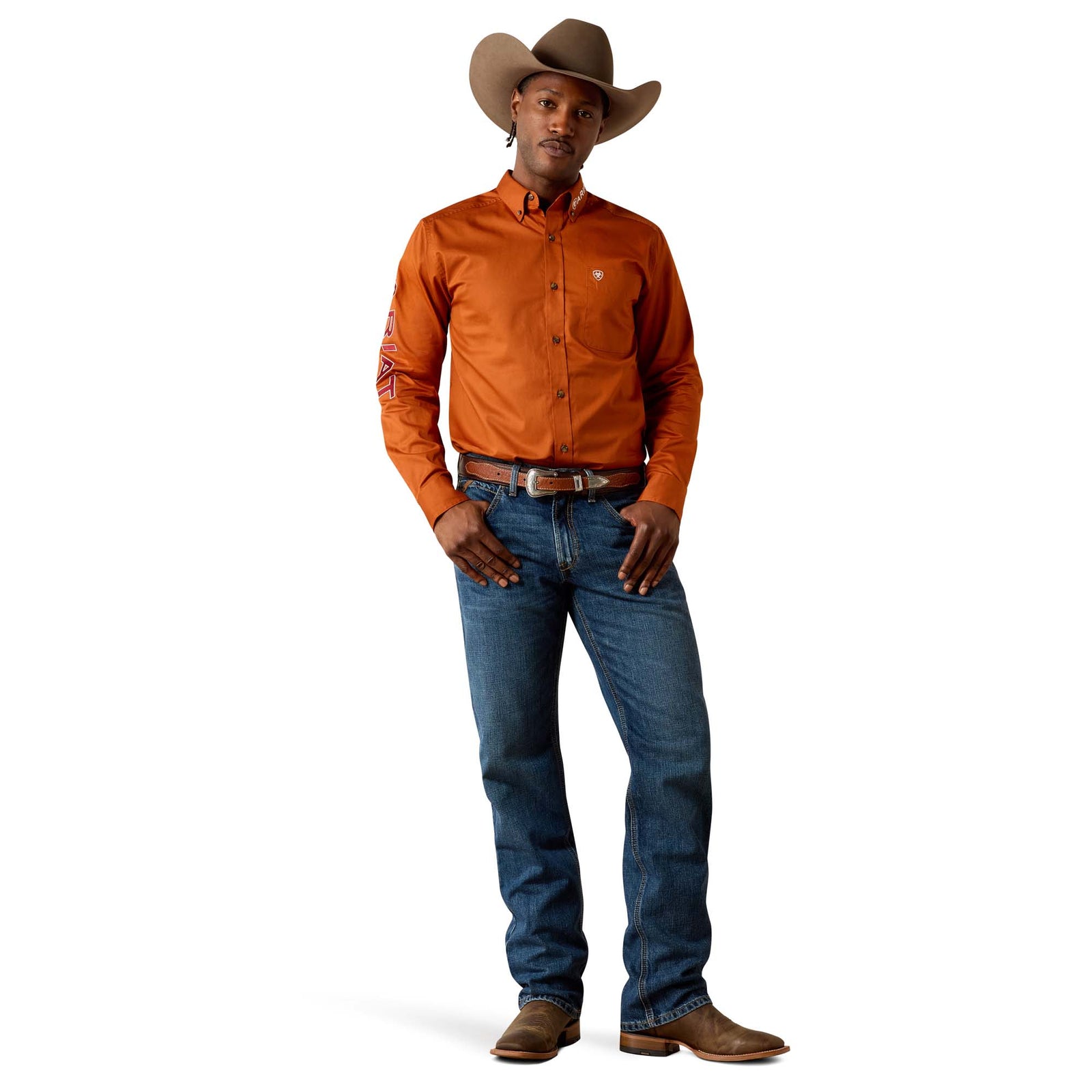 Man wearing an orange shirt, blue jeans, and a cowboy hat on a white background