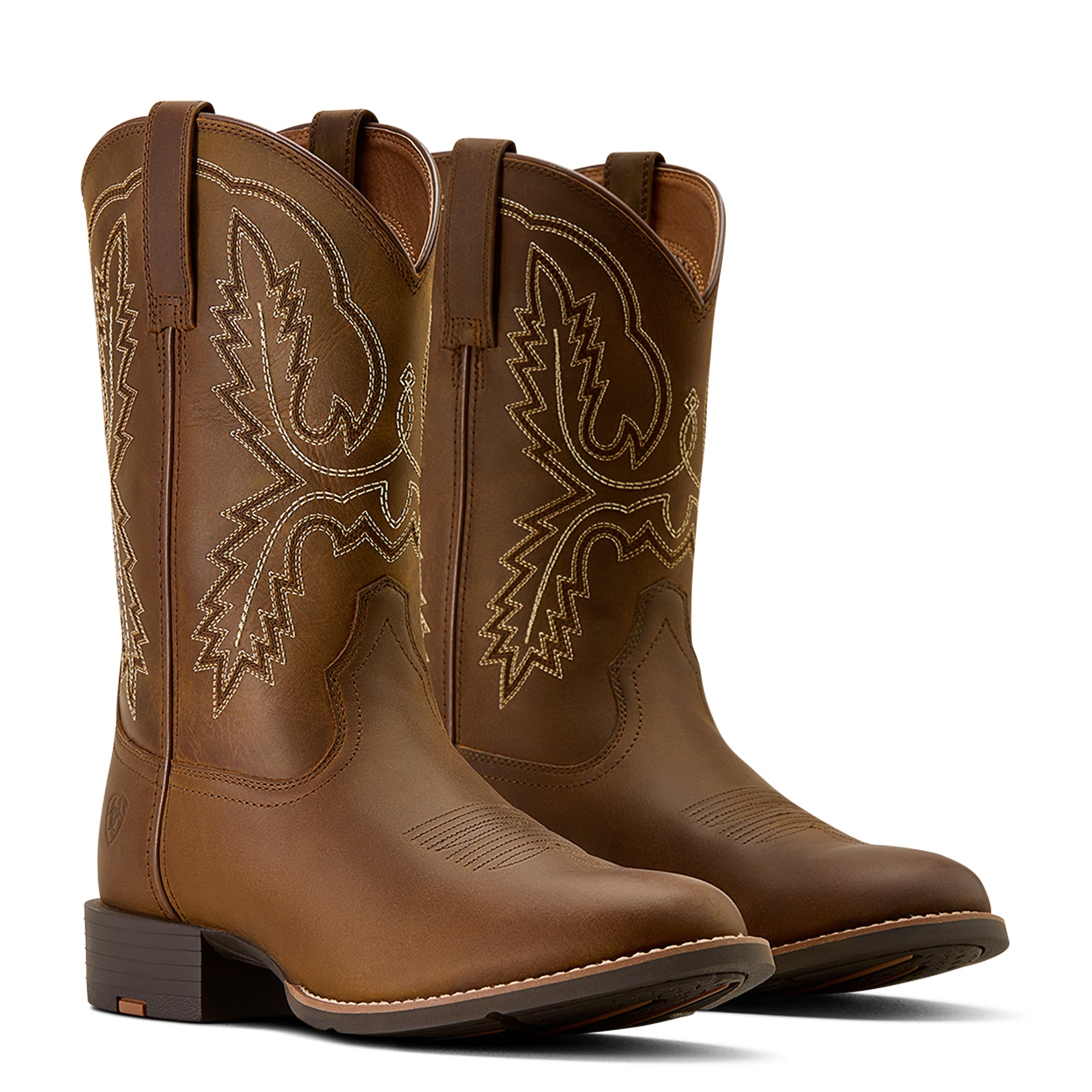 Pair of brown cowboy boots with intricate designs on a white background