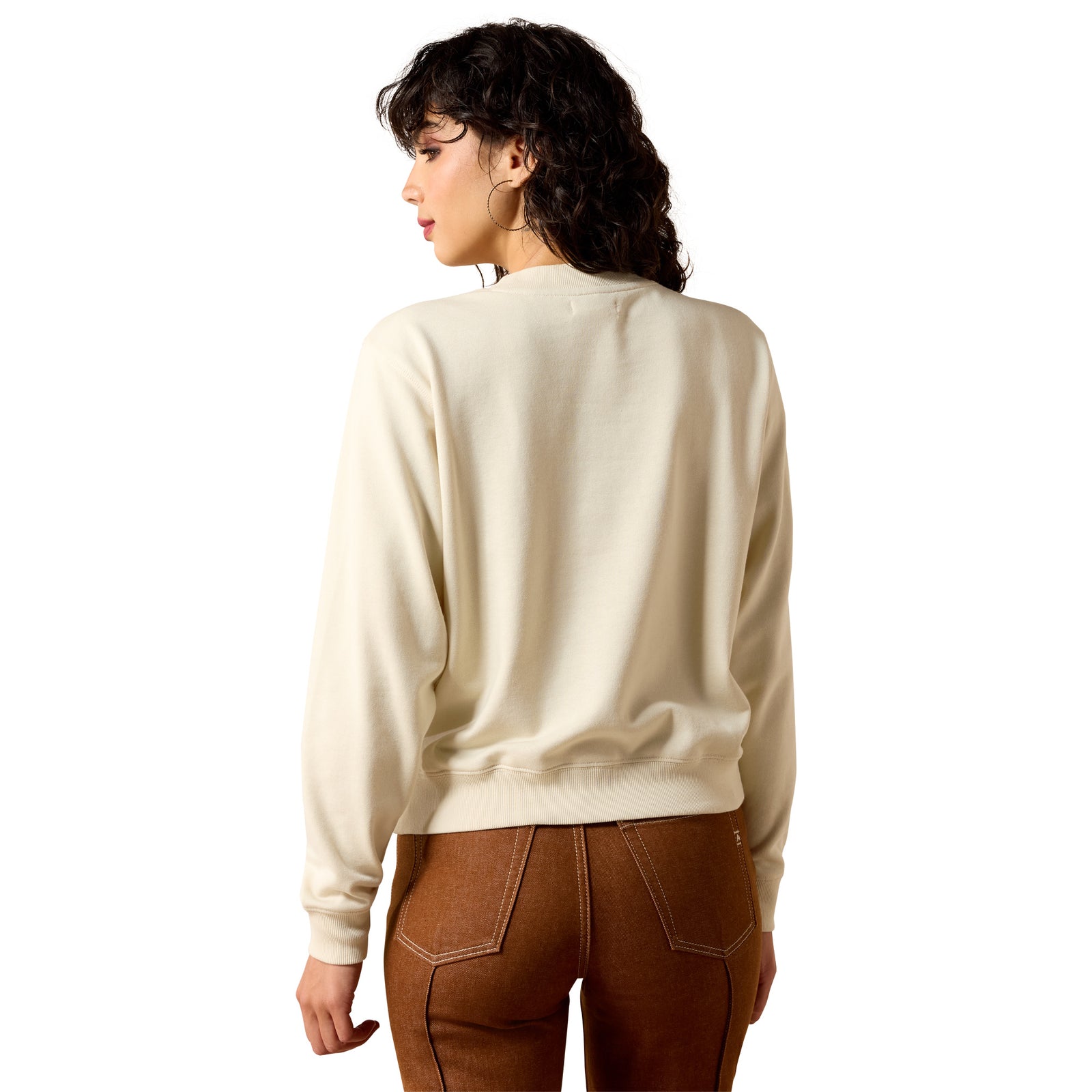 Woman wearing a beige sweater and brown pants on a white background
