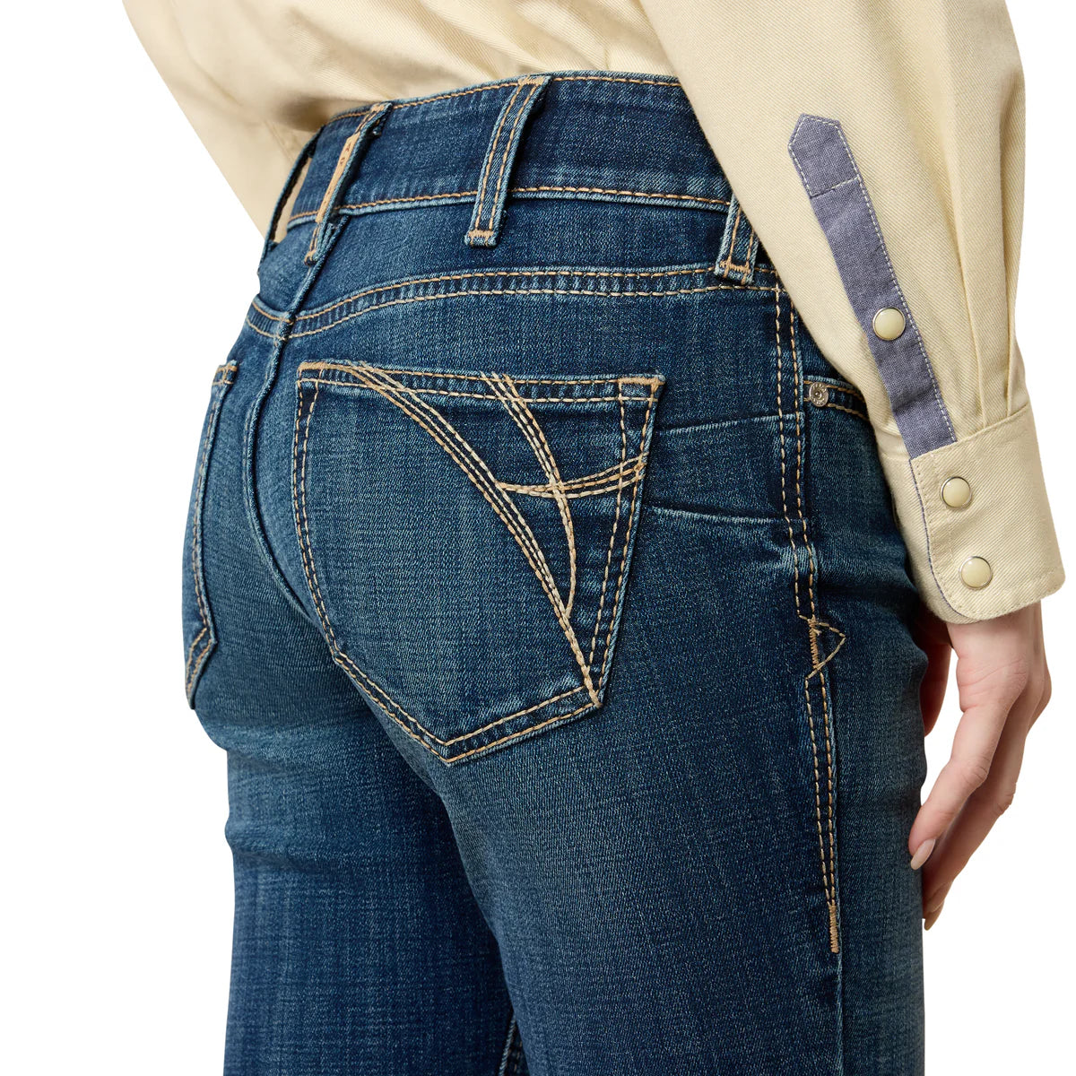 Close-up of blue jeans with a beige shirt in the background