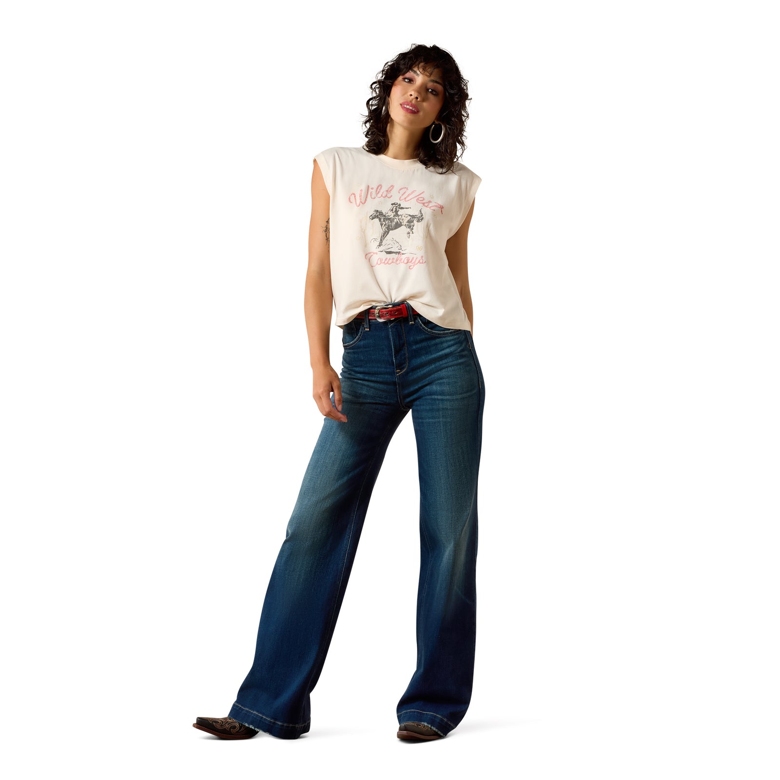 Woman wearing a white sleeveless shirt with a graphic design and blue jeans on a white background
