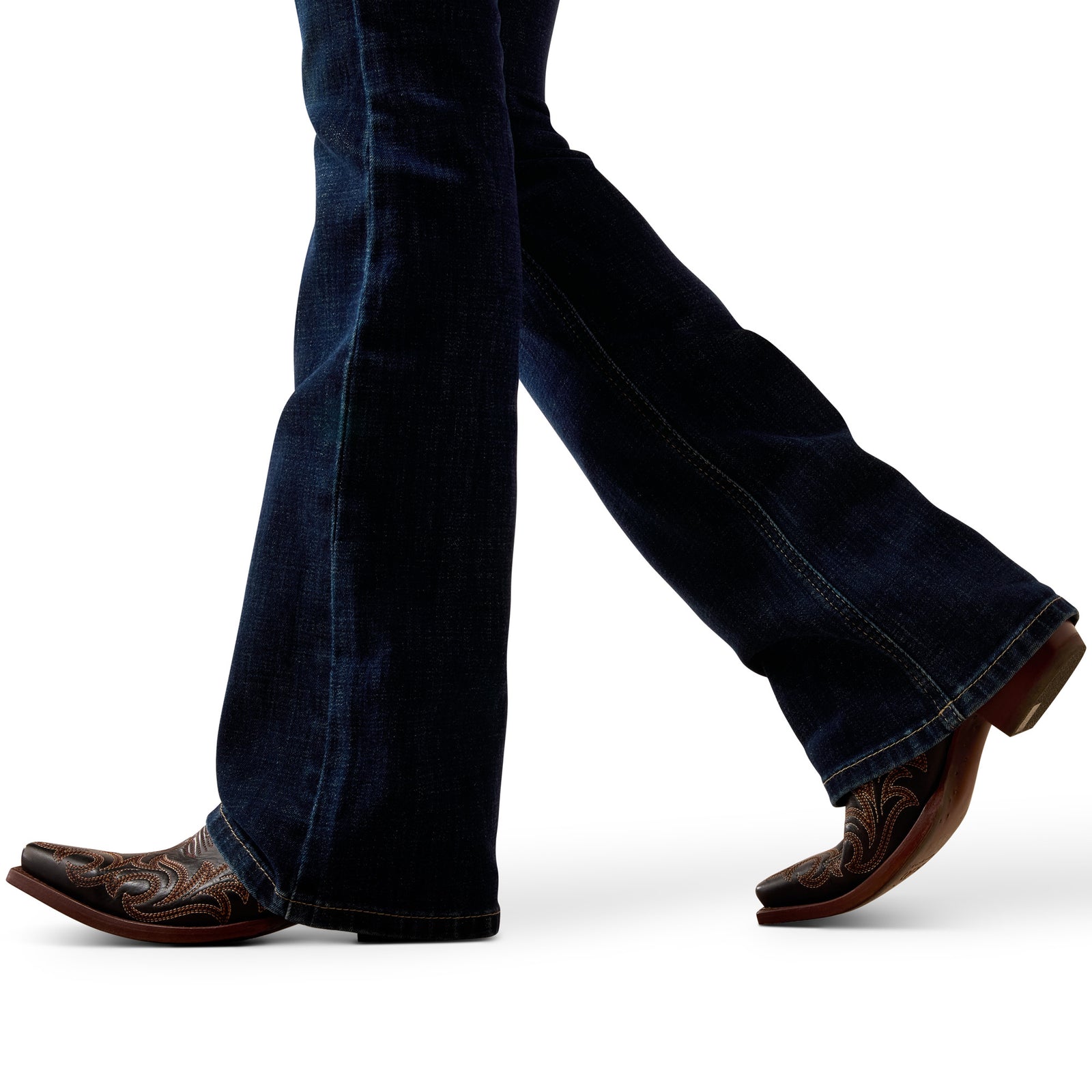 Close-up of legs wearing blue jeans and brown cowboy boots on a white background
