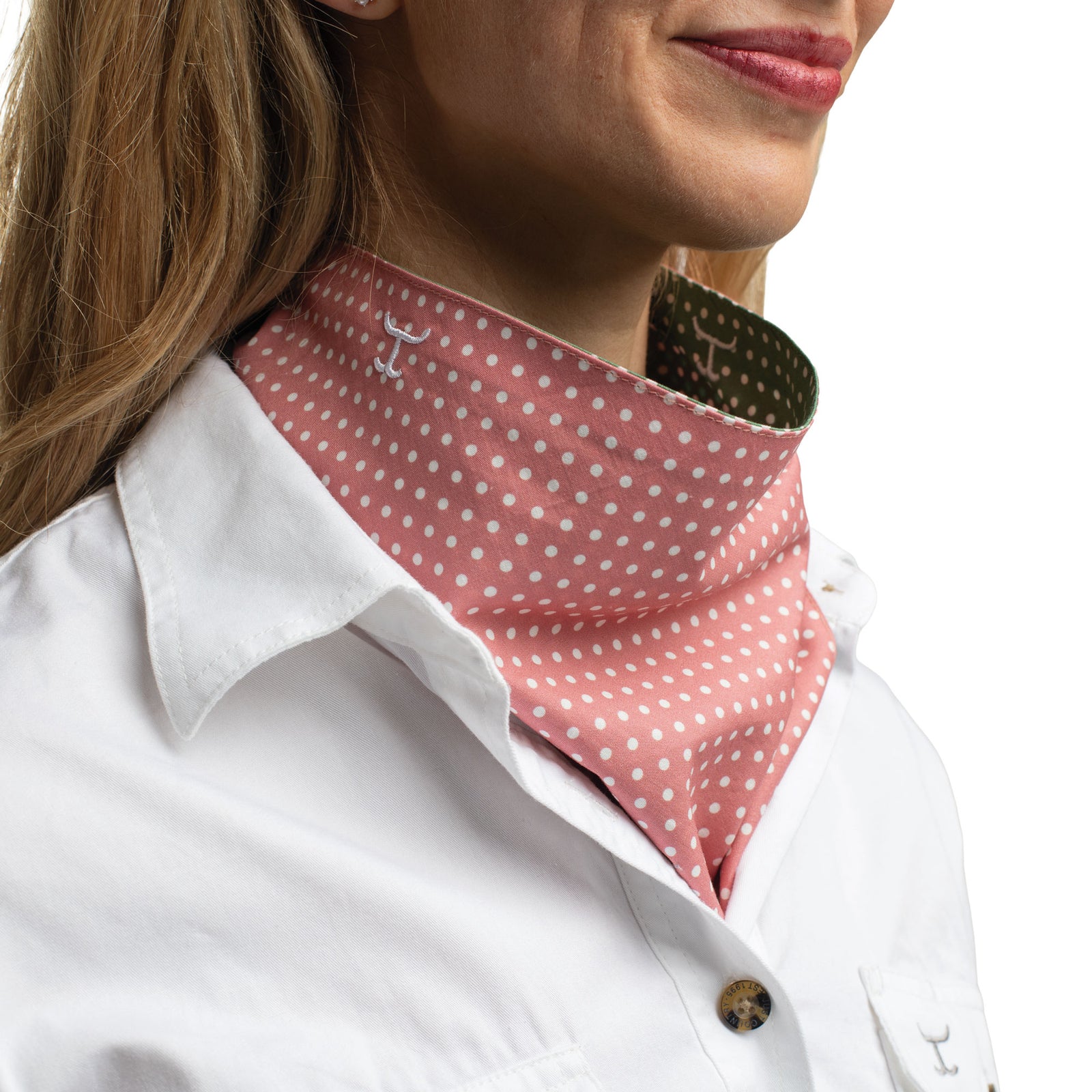 Person wearing a pink polka dot neck gaiter with a white shirt.