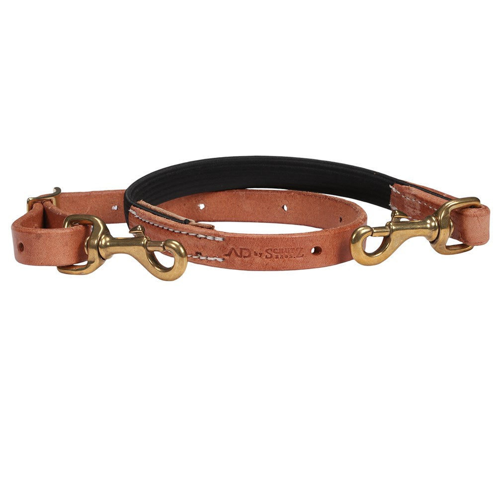 A tan leather dog collar with a black padded inner lining and gold-tone metal hardware, including brass-colored snap hooks and a buckle, shown against a plain white background.