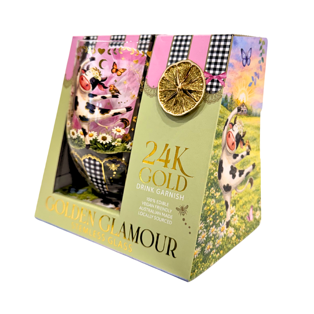 A boxed drink garnish set labeled '24K GOLD Drink Garnish' and 'Golden Glamour' in pale green packaging, featuring a decorative egg-shaped garnish with pink, black-and-white gingham, gold leaf, butterflies, flowers, and a dried orange slice on the front.