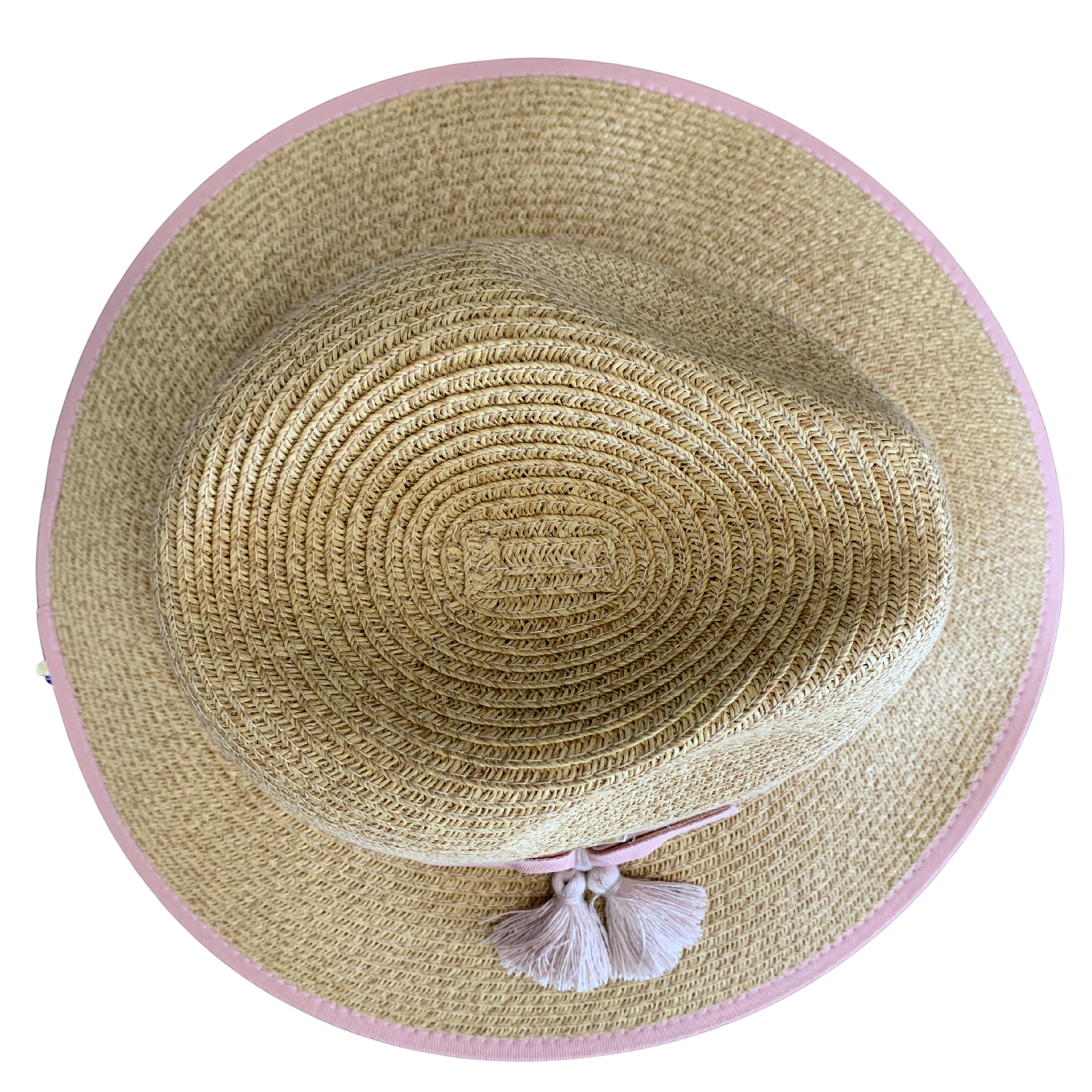 A top-down view of a woven straw sun hat with a light pink trim and a matching pink bow with white tassels, set against a plain white background.