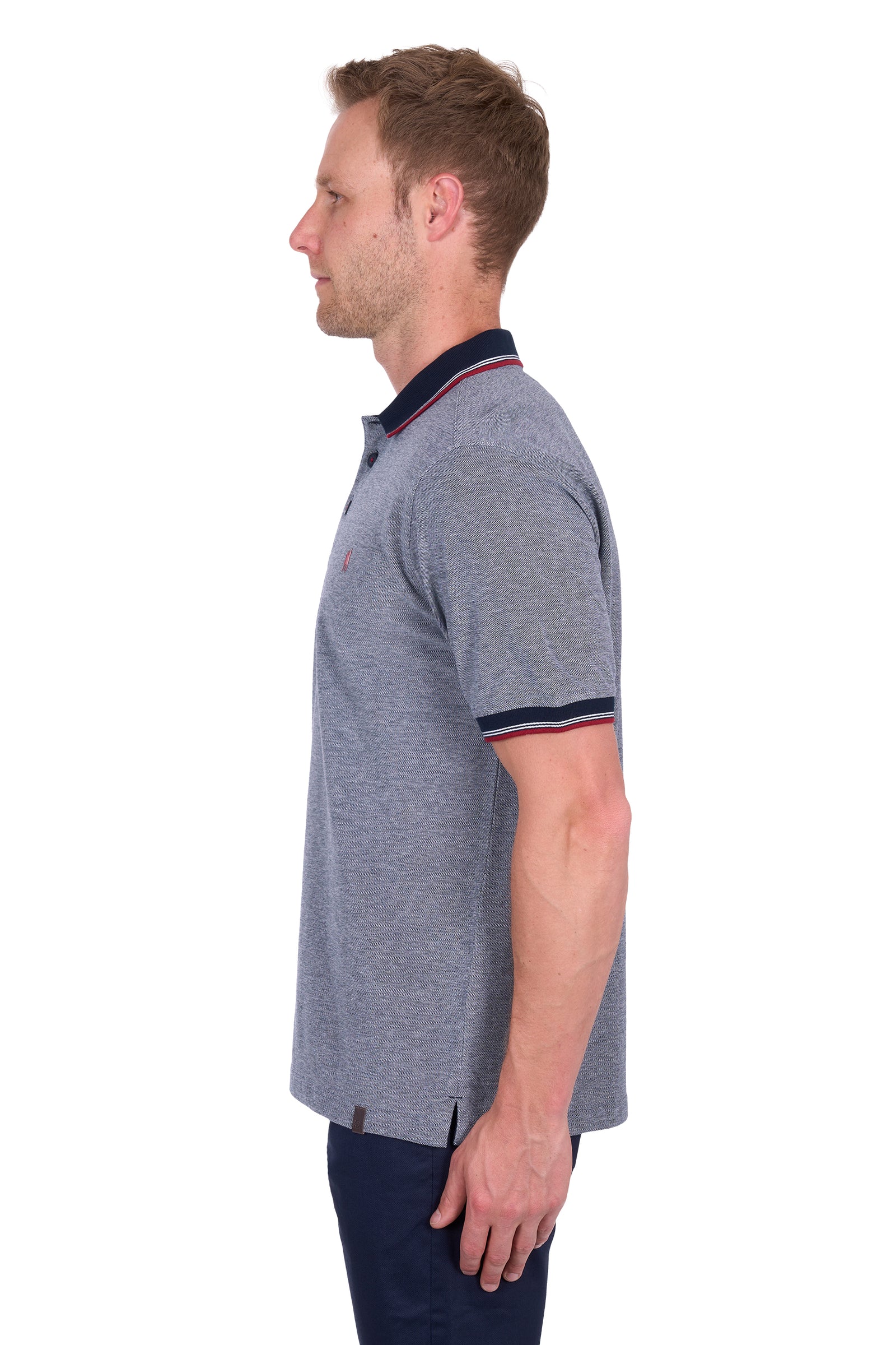 Side view of a man wearing a Thomas Cook Men's Dan Tailored S/S Polo. Navy Marle polo shirt with navy accents on a white background