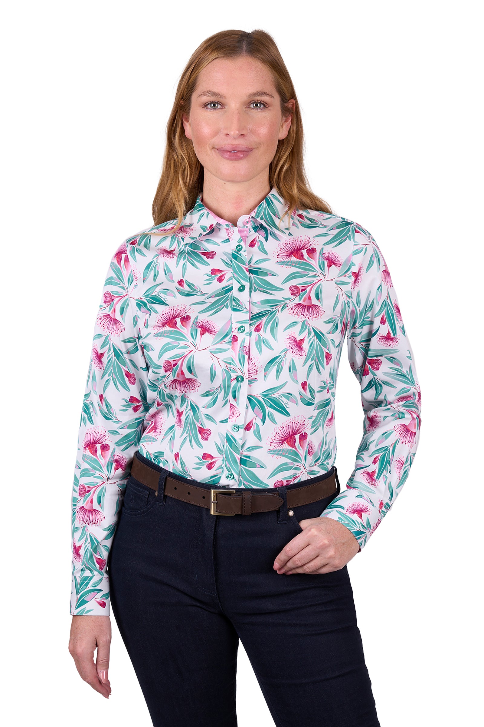 Thomas Cook Women's Florence L/S Shirt. A woman wearing a long-sleeved floral shirt and dark pants. The shirt features a geometric pattern with pink and green colors.