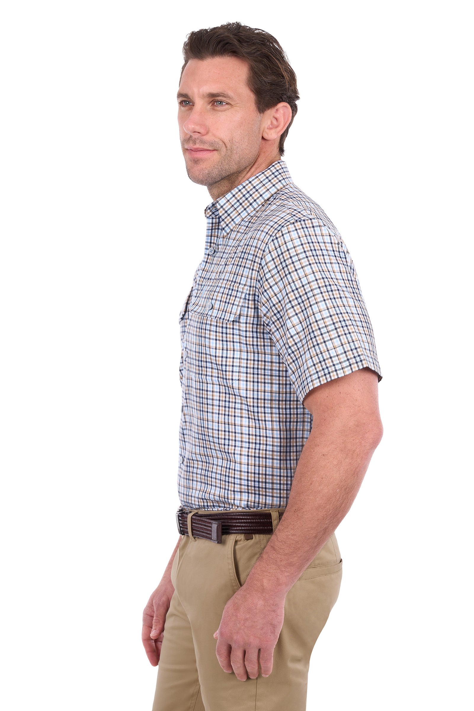A man shown in profile wearing a short-sleeve button-down shirt with a blue, white, and tan plaid pattern, paired with khaki pants and a dark belt, against a plain white background.