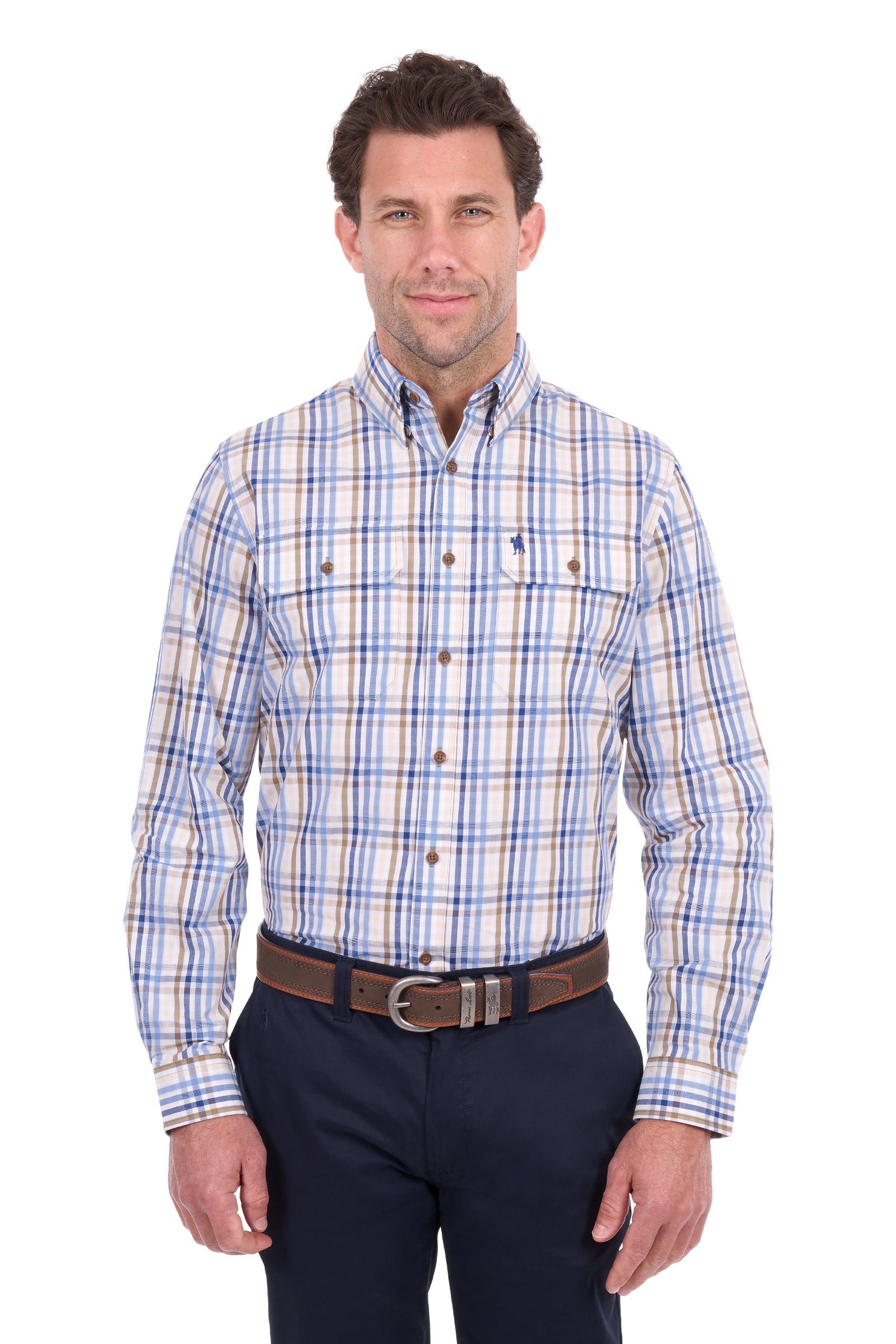 A man wearing a long-sleeve button-down plaid shirt with blue, white, and tan stripes, paired with dark navy pants and a brown belt, photographed against a solid white background.